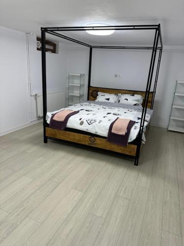 奥托佩尼Airport Confort House的一间卧室配有一张床,铺有木地板