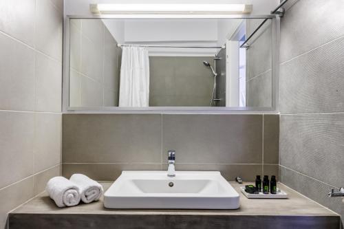 斯科派洛斯Aperitton Hotel的一间带水槽和镜子的浴室