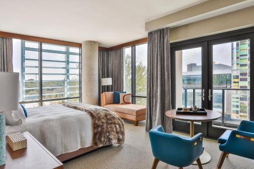 达拉斯Drey Hotel的酒店客房带一张床、一张桌子和椅子