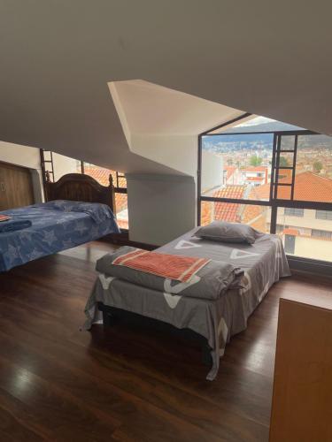 昆卡Evangelio Inn的一间卧室设有两张床和大窗户