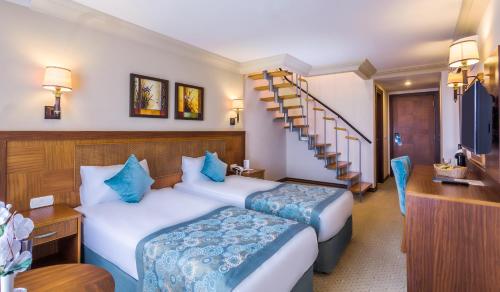 锡德Villa Side Hotel的酒店客房带两张床和楼梯
