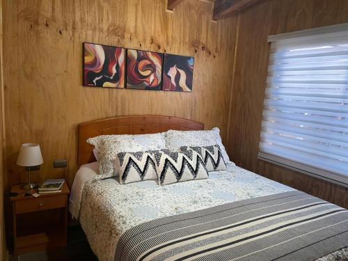 富塔莱乌富Cabaña el Arrayan Futaleufú的一间卧室配有带两个枕头的床和窗户