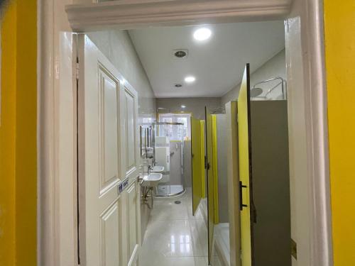 波尔图Owls Hostel的浴室设有黄色和绿色的墙壁和水槽