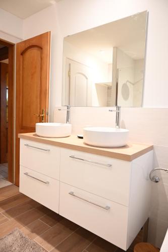 鲁法克Gîte l'Avant的一间带两个盥洗盆和大镜子的浴室