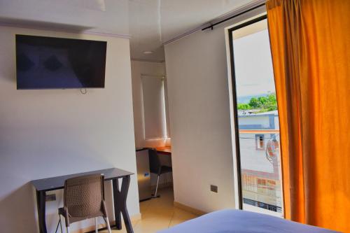 阿瓜奇卡Hotel El Sol Inn的客房设有一张床和一个美景窗户。