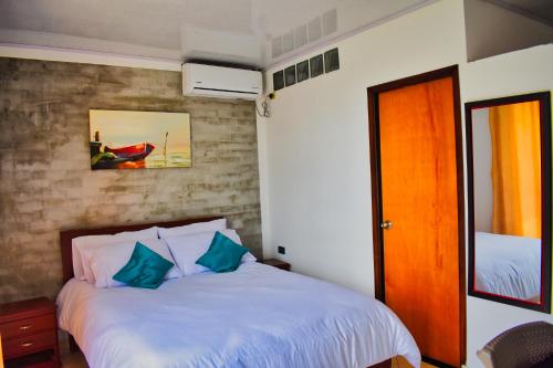 阿瓜奇卡Hotel El Sol Inn的一间卧室配有一张带蓝色枕头的床