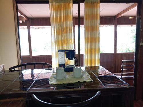 图里亚尔瓦Hotel Green Mountain的一张桌子,上面有2杯,上面有咖啡壶