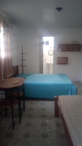 塔曼达雷Villa Tamandaré的一间卧室配有一张蓝色的床和一张桌子