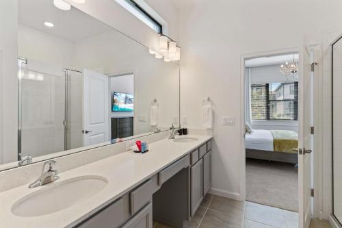 奥兰多6103 High Seas Drive的一间带两个盥洗盆和大镜子的浴室