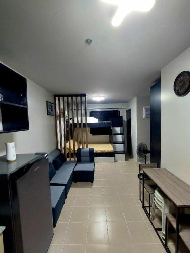 Lapu Lapu CityPlumera Homes的客厅配有蓝色的沙发和床。