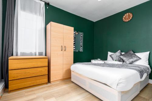 伦敦City Gate Guest House的一间卧室设有绿色的墙壁、一张床和窗户