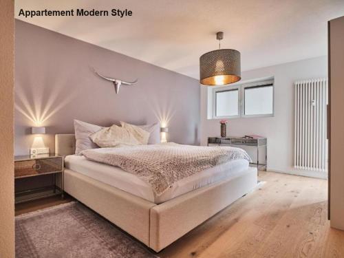 施卢赫湖Villa Sunside Schluchsee - Appartements Modern Style & Superior的一间卧室配有一张大床和吊灯