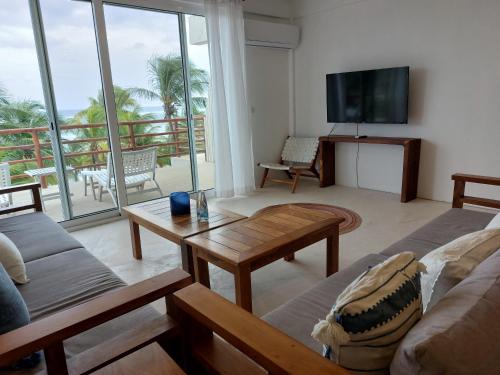玛哈威Noah Beach Hotel & Suites的带沙发和电视的客厅