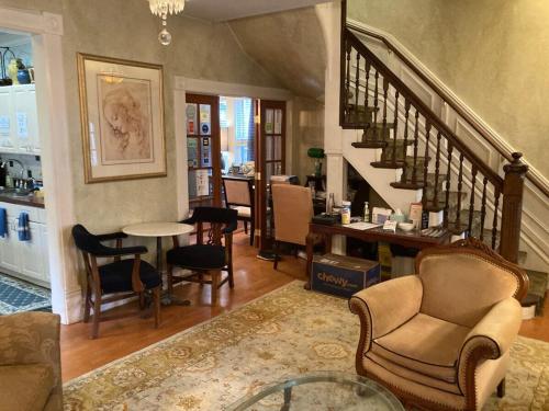 芝加哥The Villa Toscana的客厅设有楼梯、椅子和桌子