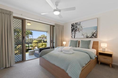 日出海滩海滩客度假酒店的一间卧室设有一张床和一个阳台