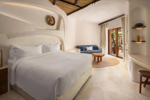 切尔沃港Hotel Cala di Volpe, a Luxury Collection Hotel, Costa Smeralda的一间带白色床的卧室和一间客厅