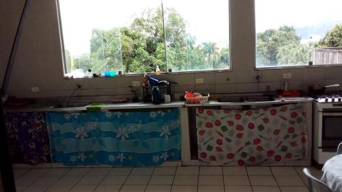 圣维森特岛Eco hostel 013的带水槽的厨房和2扇窗户
