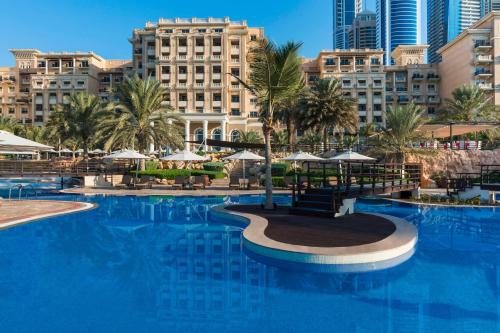 迪拜The Westin Dubai Mina Seyahi Beach Resort and Waterpark的一座棕榈树和建筑的大型游泳池