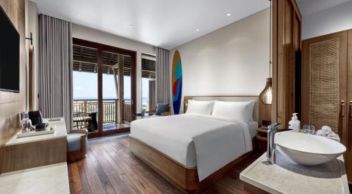 坎古Holiday Inn Resort Bali Canggu, an IHG Hotel的一间卧室配有一张床和一个水槽和一个浴缸