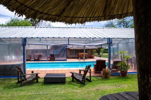 梅塞德斯Posada de Campo San Cono的凉亭设有游泳池、桌子和椅子