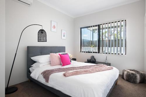 珀斯U7/560 Cozy Lovely的白色卧室配有带粉红色枕头的大床