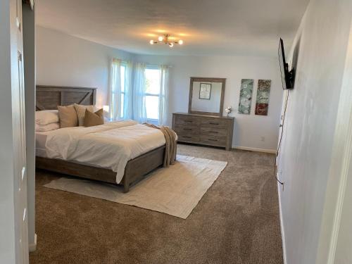GroveportNewley Remodel 5 - Bedroom Home Sleeps 16的一间卧室配有一张床、一个梳妆台和一扇窗户。