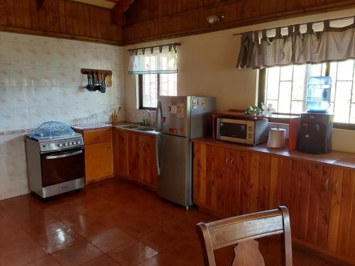 安加罗阿Te Ra'a Travel - Cabaña equipada的厨房配有炉灶、冰箱和微波炉。
