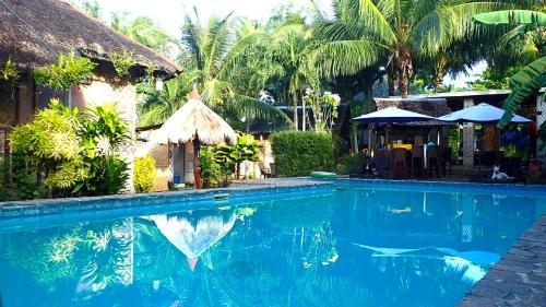 邦劳蒂基岛天堂度假村的棕榈树屋前的游泳池