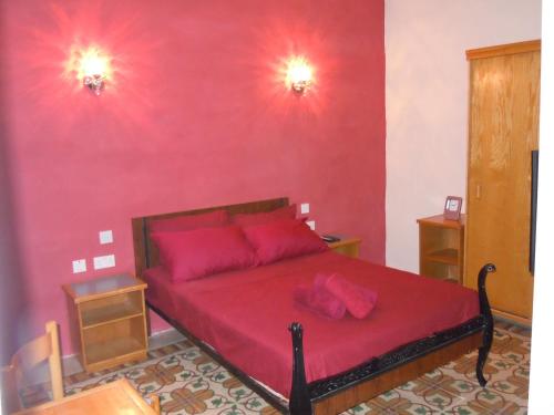 比尔古20号度假屋的一间卧室配有红色的床和粉红色枕头