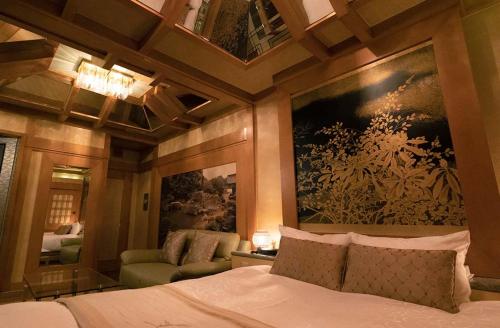 京都Hotel Dion ホテル ディオン - Adult Only的卧室配有一张床,墙上挂有绘画作品