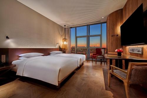 北京北京大兴国际机场木棉花酒店的一间卧室设有一张大床和一个大窗户