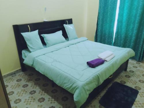 KiambuBONNY KINGs FARMSTAY的一间卧室配有一张大床,上面装有紫包