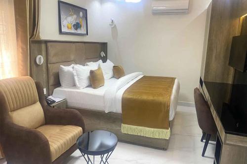 阿布贾Castle Estate Apartments 3的配有一张床和一把椅子的酒店客房