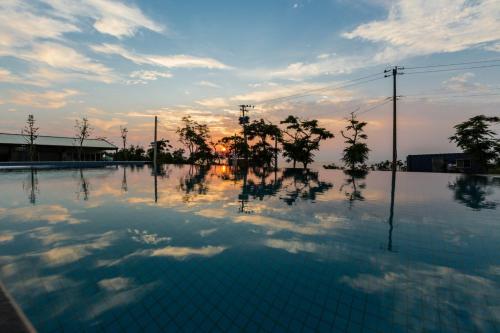 小琉球岛朵猫猫海景民宿的一个空的游泳池,背景是日落