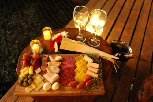 Agustín CodazziMilagros Glamping的一张木桌,上面放着奶酪和酒杯托盘
