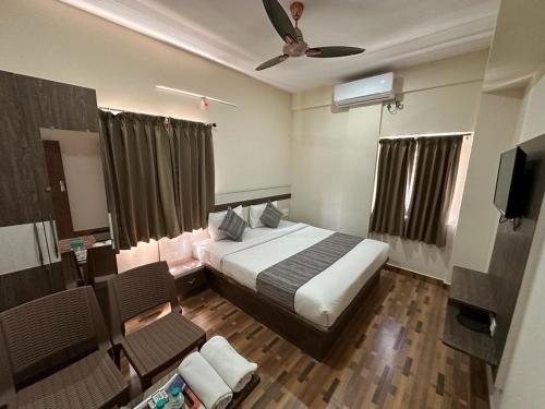 班加罗尔Hotel JP Grand的一间酒店客房,配有一张床和一台电视