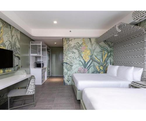San JoseAstoria Palawan的一间酒店客房,设有两张床和电视