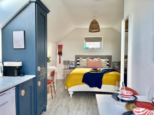 韦克斯福德The Loft Curracloe, on Wexfords Coastal Scenic Route的一间带黄色和蓝色床的卧室和一间厨房