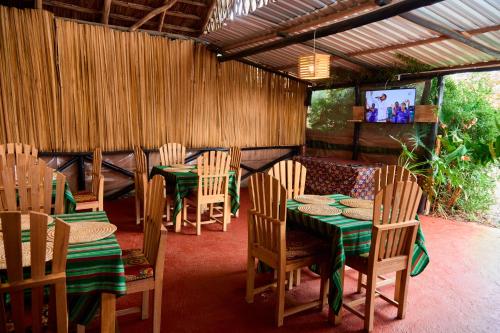 阿鲁沙freedom inn的餐厅设有木桌、椅子和电视。