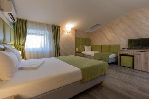 布加勒斯特科维沃斯酒店的酒店客房设有两张床和电视。