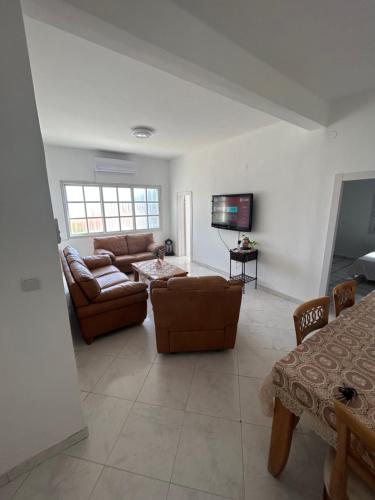 提比里亚Casa de Galilee的带沙发和电视的客厅