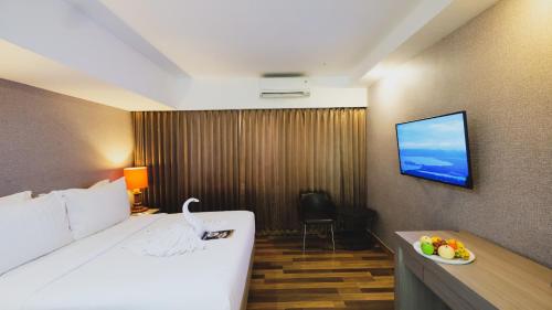 查亚普拉Hotel Suni Sentani的酒店客房,配有床和电视