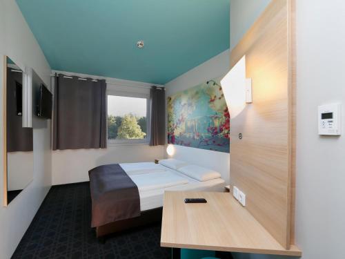 波茨坦波茨坦酒店的酒店客房配有一张床铺和一张桌子。