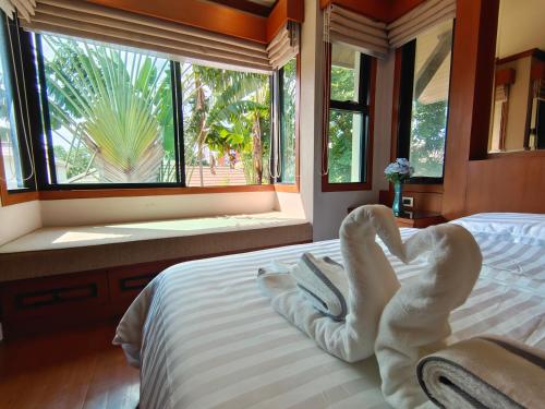 芭堤雅市中心Baan Natcha Villa的一间卧室,床上有毛巾动物
