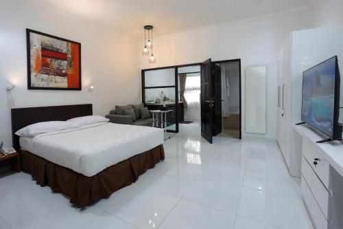 雅加达ARCS House Menteng by Jambuluwuk的一间卧室设有一张床和一间客厅。