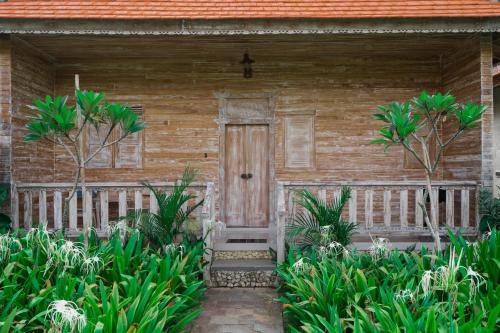 乌鲁瓦图Agaru Villa Uluwatu by The Lavana的木房子,带木门和一些植物