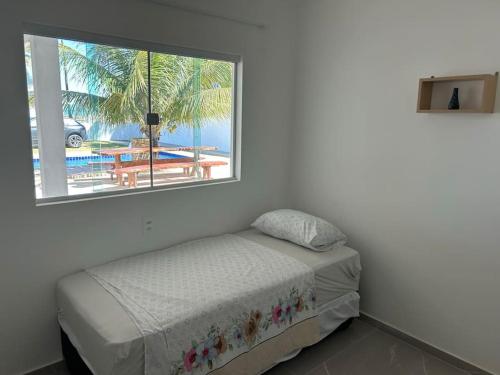 Barra do SirinhaémBeachhouse in Barra do Sirinhaém的一间卧室设有一张床和一个窗口