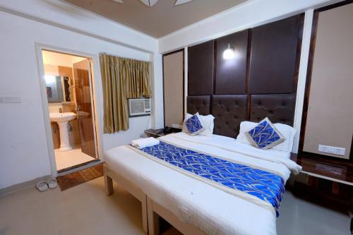 新德里Family Hotel Near IGI Airport的一间卧室设有一张大床和一个大镜子