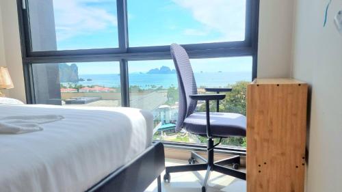 奥南海滩A404-nice Seaview One Bedroom At Ao Nang Beach的卧室配有一张床和一张椅子,位于窗户前