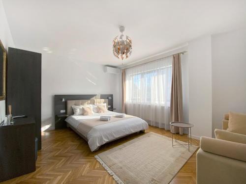 锡盖图马尔马切伊Vila Roza的一间卧室配有一张大床和一个吊灯。